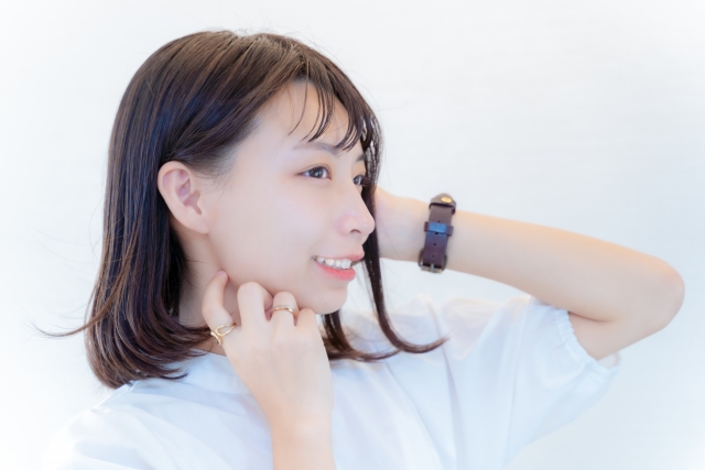 滑らかで艶のある肩までのダークブラウンヘアの女性が横顔で微笑む様子。健康な毛髪の成長やヘアサイクルの正常な状態を象徴するイメージカット。