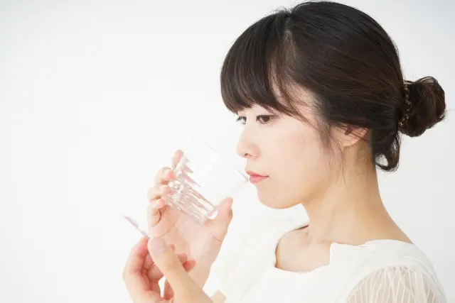 自毛植毛手術を控えた女性が市販薬の服用をためらう様子を表すイメージ写真。服薬の自己判断が手術リスクを高める可能性があることを示唆
