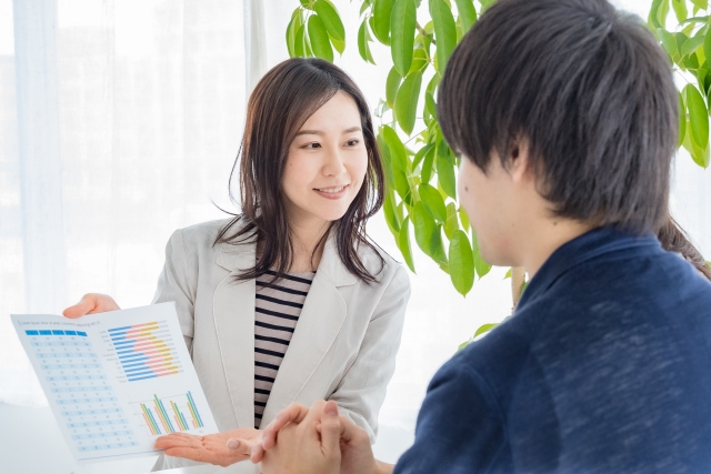 専門知識のように見える用語や複雑なデータ表で信頼性を装い、男性を安心させる無資格者の女性｜無資格施術による自毛植毛トラブルのリスクとISHRSの国際的警告を象徴するストック画像