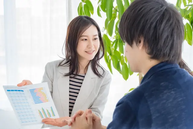 専門知識のように見える用語や複雑なデータ表で信頼性を装い、男性を安心させる無資格者の女性｜無資格施術による自毛植毛トラブルのリスクとISHRSの国際的警告を象徴するストック画像