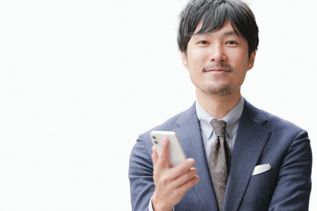 整った口ひげとあごひげを持つ日本人男性が正面からカメラを見つめる様子。ヒゲ植毛で実現できる自然で洗練されたヒゲスタイルを表現した装飾用イメージ