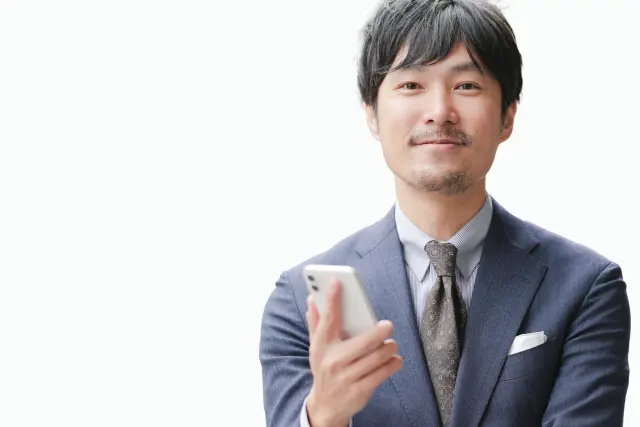 整った口ひげとあごひげを持つ日本人男性が正面からカメラを見つめる様子。ヒゲ植毛で実現できる自然で洗練されたヒゲスタイルを表現した装飾用イメージ