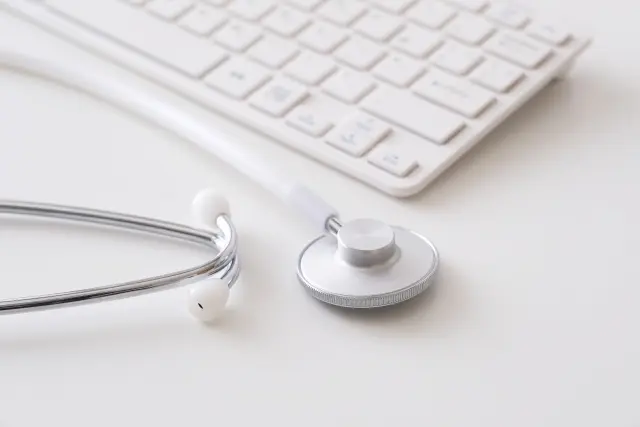 聴診器と白いパソコン用キーボードが机の上に置かれている医療イメージ。安全な植毛手術や信頼できる医師選びの重要性を象徴するイメージカット