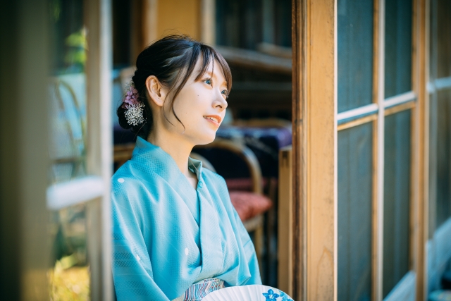 青い浴衣を着た女性が、整えられた美しい髪を揺らしながら空を見上げる様子。髪の健康と内面のゆとり、ライフスタイルのバランスが髪の美しさに影響することを象徴するシーン。