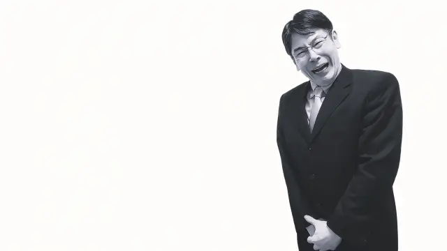 前立腺や下腹部の強い痛みに苦しむ中年男性の白黒写真。健康不安や体内の異常を訴える様子を象徴的に表現したイメージ。男性型脱毛症と前立腺がんの関連性に関する医療記事内の装飾用ビジュアル