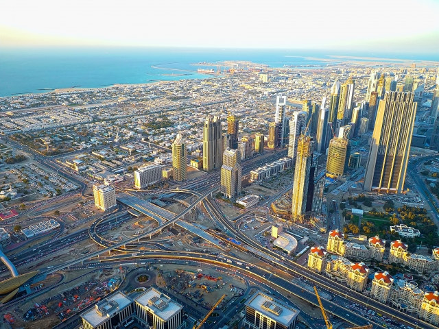 ドバイの都市全景を空撮した写真。国際毛髪再生外科学会（ISHRS）の世界ライブ手術ワークショップが開催されたドバイ・ヘルスケア・シティの近未来的な医療施設群や、急速に発展する中東の国際都市としてのドバイの先進性を象徴するイメージ。