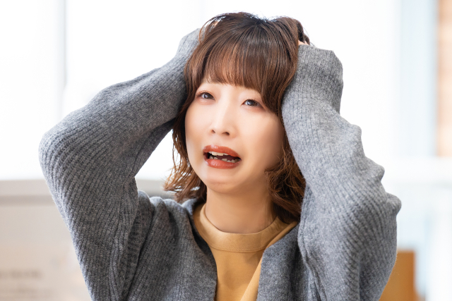 十分な相談や準備をせずに植毛手術を受けた結果に強い後悔と衝撃を感じ、両手を頭に当てて叫ぶ女性のイメージ写真。後悔しないための正しい意思決定と医師との対話の重要性を伝えるコラム記事に関連