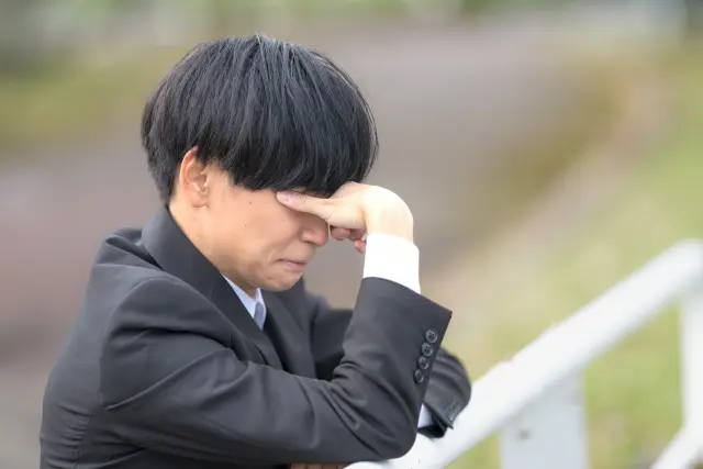 無資格者による植毛手術によって深刻なトラブルに巻き込まれ、後悔と絶望の中で静かに涙を流す男性患者のイメージ。信頼していた施術者が医師ではなかったことに気づいた瞬間の苦悩を象徴するビジュアル。