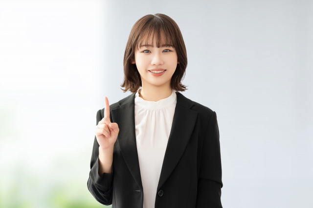 植毛手術前に確認すべき大切なポイントを丁寧に説明する笑顔の女性講師。費用・痛み・仕上がりに関する疑問を解消し、安心して手術に臨むための心構えを伝える場面。