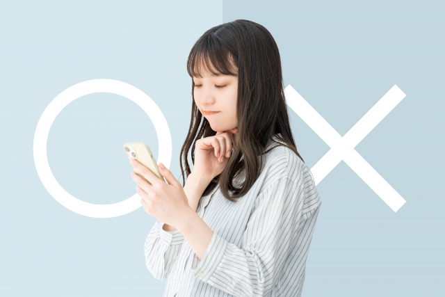 スマートフォンを見つめながら思案する若い女性。背景には〇と×のマークが分かれて表示されており、信頼できる植毛クリニック選びに慎重になる様子を象徴したイメージ写真