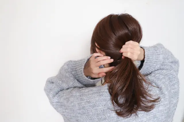 艶やかでボリュームのあるポニーテールを後ろ姿で束ねる女性。光沢と強さを備えた髪は、ポリフェノールなど自然由来成分による育毛・美髪効果を体現しており、健康な毛髪環境の理想的なイメージを表現している。