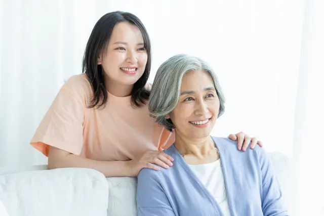 白髪の高齢女性と黒髪の若い女性が並ぶ様子。加齢による髪の色の変化と世代間の違いを象徴するイメージ｜白髪の科学と老化に関する解説記事より