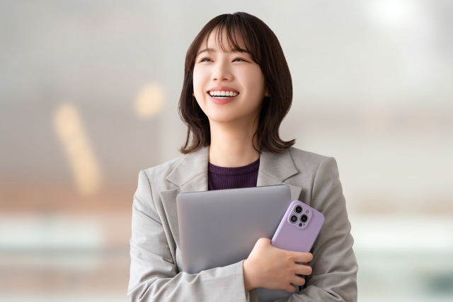 肩までの長さの髪が毛先でふんわりカールした女性が、笑顔で上を見上げている様子。毛髪移植によって自然で若々しい髪型を取り戻し、自信を取り戻した印象を与える写真。移植後のヘアラインやボリューム感が自然に見える仕上がりを象徴するイメージカット。