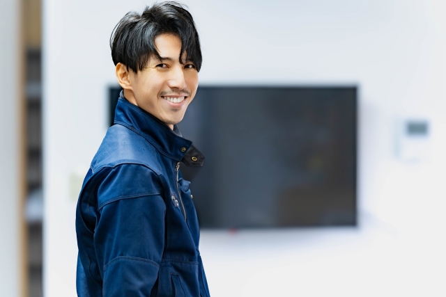 整った口ひげを蓄えた日本人男性が横顔で穏やかに微笑む様子。理想のヒゲスタイルがもたらす自信や清潔感を視覚的に伝えるヒゲ植毛関連の装飾画像