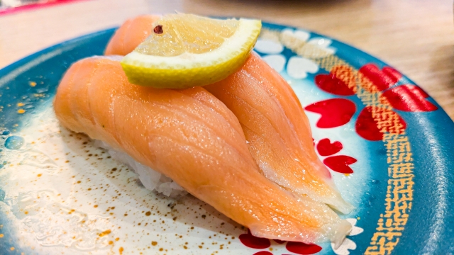 オメガ3脂肪酸が豊富なサーモンを使った握り寿司二貫。髪や頭皮の健康をサポートする栄養素を含む食材として、美髪を意識した食生活に役立つ例。