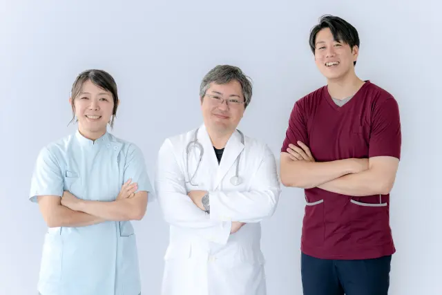 薄毛や抜け毛の診察に対応する医師と看護師が笑顔で立つ、安心感のある専門クリニックのイメージ写真