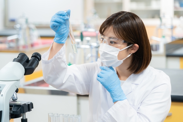 再生医療の研究室でPRPや幹細胞培養液の性状を慎重に観察する女性研究者──薄毛治療の精密な成分解析と安全性確認の一環
