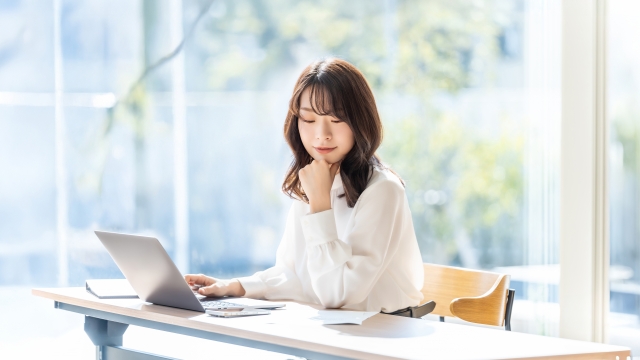 自毛植毛やFUEの最新技術について資料を読みながら調べ、比較検討している女性のイメージ。薄毛治療や植毛手術に関する正確な情報を得ようとする、意識の高い読者像を象徴。