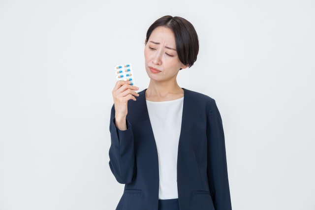 自毛植毛手術を前に、市販薬の服用に不安を感じる女性のイメージ。薬のリスクを見極め、医師に相談する重要性を表現