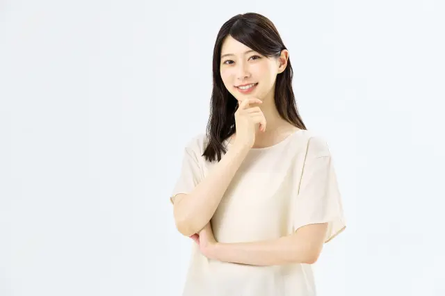 笑顔の女性が腕を交差させ、右手の人差し指にあごを乗せてポーズをとる様子。清潔感のある印象は、自毛植毛後の自然な仕上がりへの関心を想起させるビジュアル。