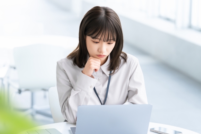 FUE法のメリットとリスクを調べながら、治療選択に迷う若い女性の真剣な表情