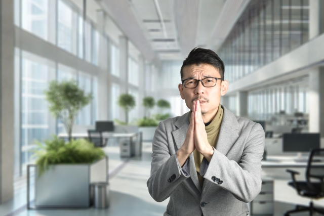 ヒゲのある眼鏡の日本人男性が懇願するようなジェスチャーをする姿。ヒゲの悩みを解決したいという切実な思いを表現したイメージ。