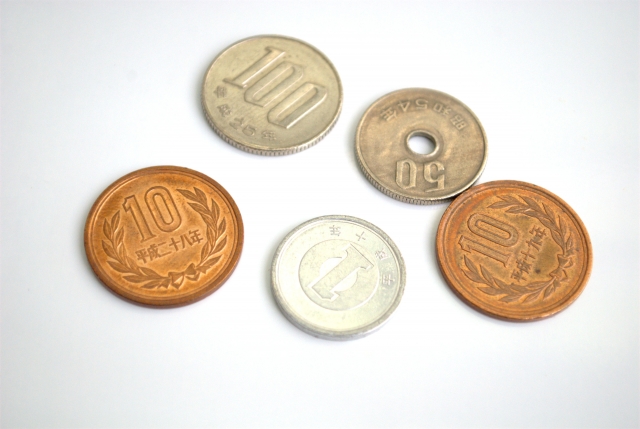 少額の硬貨が並ぶイメージ｜毛髪移植を受けられない経済的困難と小さな寄付の大きな支援効果を象徴