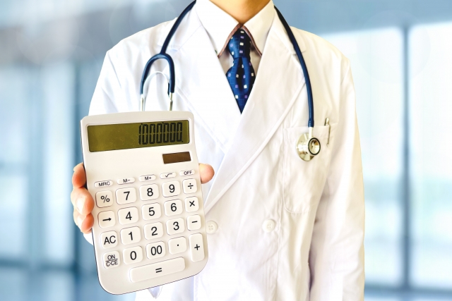 植毛手術の高額な費用を示す電卓を手に持つ白衣姿の医師の上半身。信頼できる医療機関の選択が重要であることを示唆するイメージ
