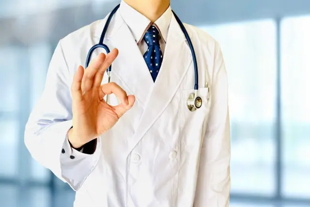 白衣を着た医師が右手でOKサインをする姿|毛髪再生医療や植毛治療の専門医による信頼感と安心感を象徴するイメージ。ISHRS世界大会に登壇する熟練の植毛外科医のイメージカットとして使用。