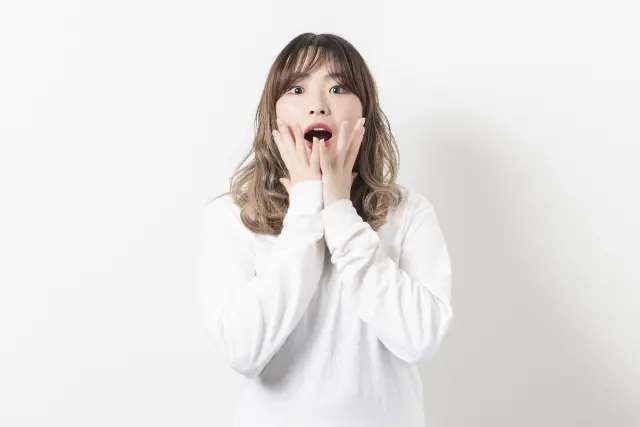 薄毛の原因や最新治療法を知って驚く女性が、口元に手を当てて目を見開く瞬間｜女性のびまん性脱毛症や自毛植毛に関する情報コラム用イメージ