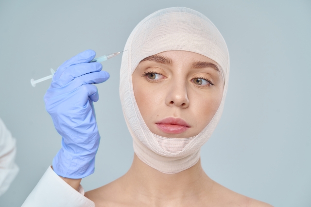 外傷や手術後に頭部に包帯を巻いた女性が、毛髪再建治療の回復途中にある様子を示すイメージ写真。オペレーション・リストアによる無償植毛支援や事故・病気による脱毛後のサポートを象徴。