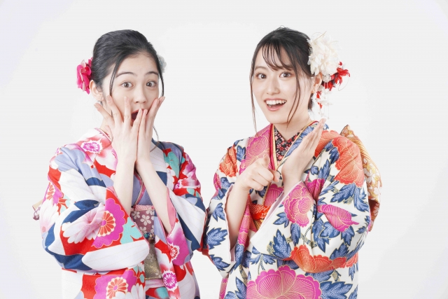 着物姿の若い女性2人が笑顔でポーズをとる様子。外見への意識が高まり、美容医療や自毛植毛への関心が広がる現代日本の若年層の価値観を象徴するイメージ