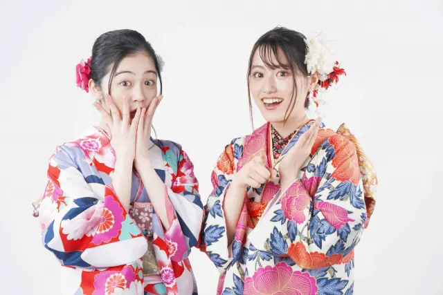 着物姿の若い女性2人が笑顔でポーズをとる様子。外見への意識が高まり、美容医療や自毛植毛への関心が広がる現代日本の若年層の価値観を象徴するイメージ