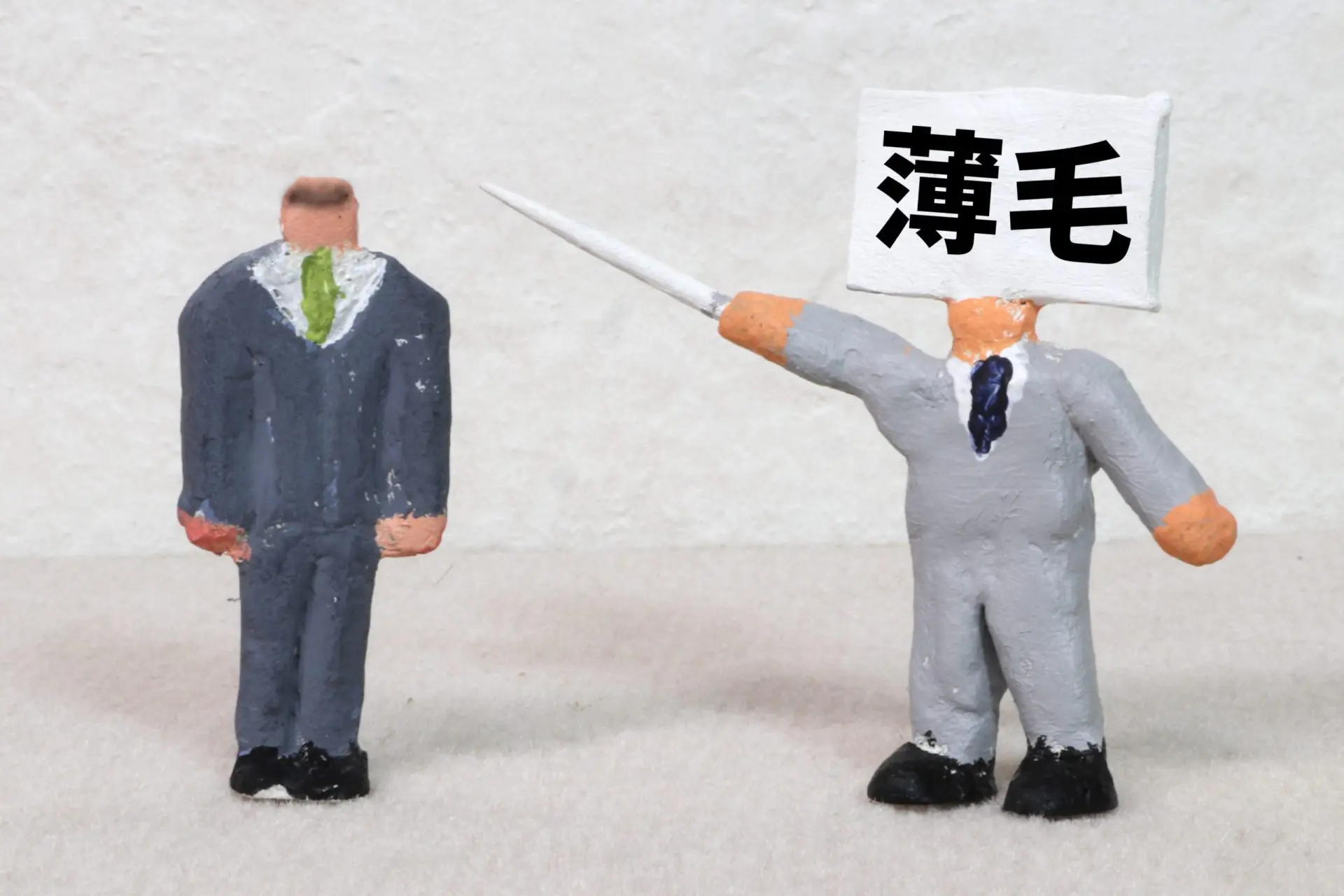 薄毛を指摘する人形