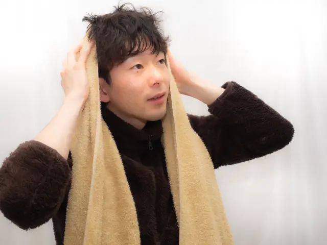 髪を拭く男性