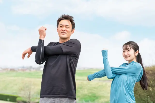 運動前のストレッチをする男女