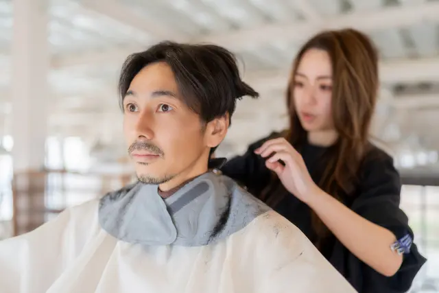 髪を切ってもらっている男性