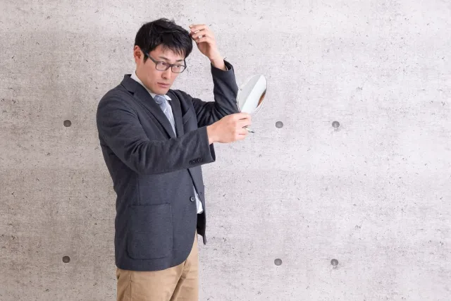 鏡を見る男性