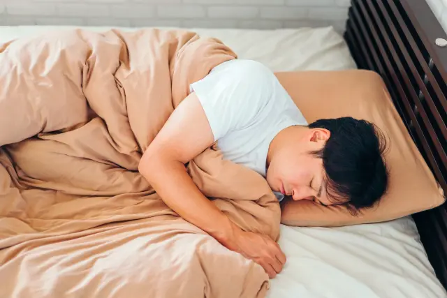 横向きで寝る男性