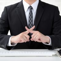 指でバツをつくるビジネスマン