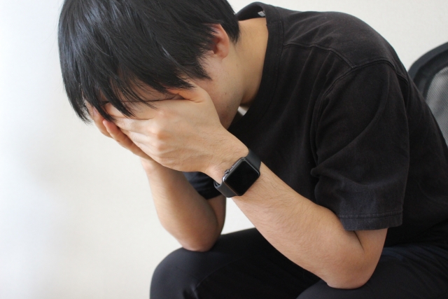 頭を抱える男性
