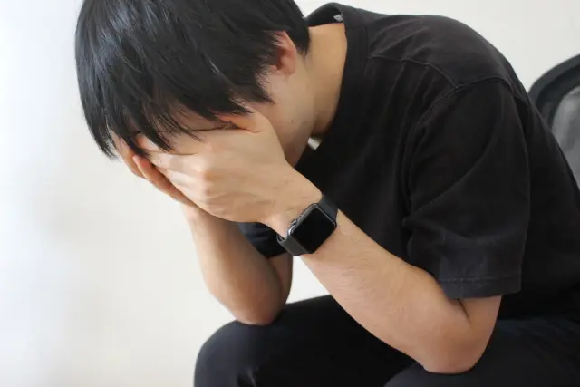 頭を抱える男性