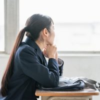 教室で悩んでいる女子高生