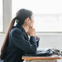 教室で悩んでいる女子高生