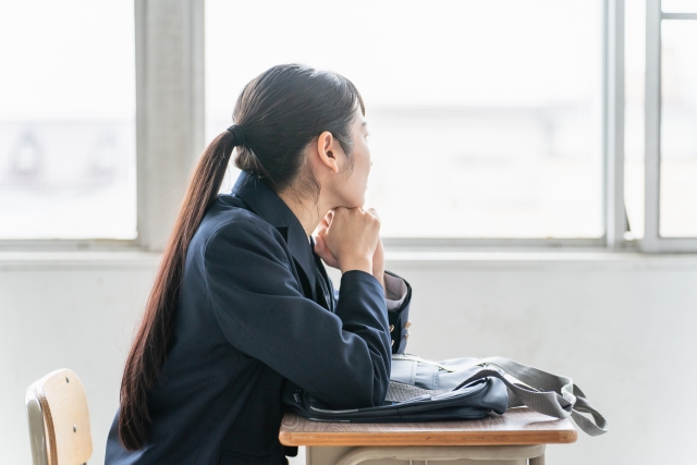 教室で悩んでいる女子高生