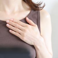 胸に手を当てる女性