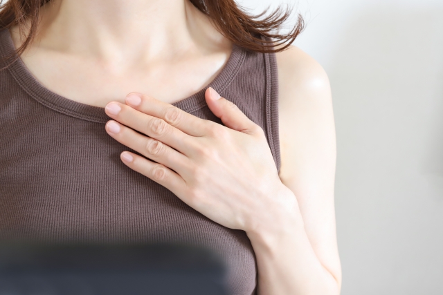 胸に手を当てる女性
