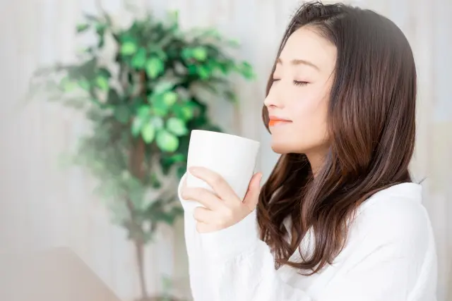 飲み物を飲む女性。カフェインは1日の合計量で管理する