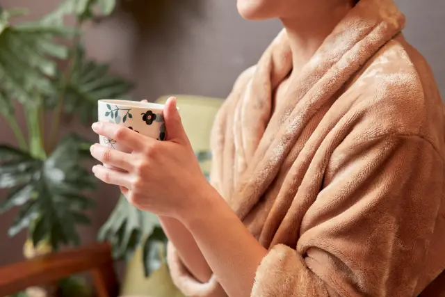 就寝前にマグカップの温かい飲み物を手にする女性