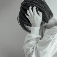 耳をふさぐ女性